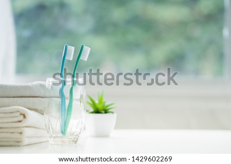 The toothbrushes in a glass and white towels with copy space in bathroom  Royalty-Free Stock Photo #1429602269