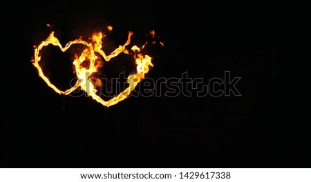Two fiery burning hearts of lovers on a black background