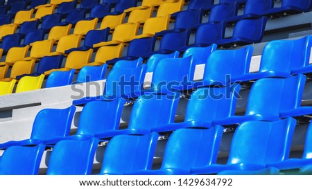 The Stadium seat blue. Rows of empty blank chairs blue and yellow on background view. Sports. Pattern texture of set chairs. Plastic seat at outdoor of Amphitheater. The Arena.