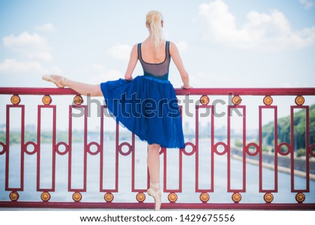 Young ballerina in ballet costume dancing in city , feeling breath of big city life and freedom	