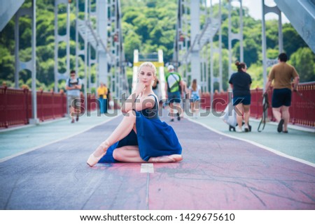 Young ballerina in ballet costume dancing in city , feeling breath of big city life and freedom	