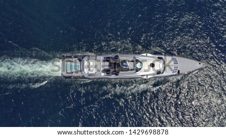 Aerial photo of luxury yacht cruising the deep blue sea of Mykonos island, Cyclades, Greece