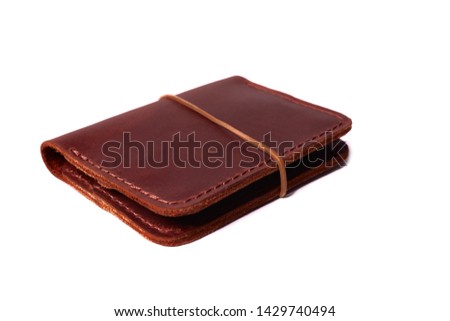 Handmade red color leather cardholder with rubber band isolated on white background closeup. Stock photo of handmade luxury accessories.