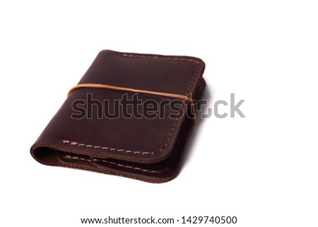 Handmade brown leather cardholder with rubber band isolated on white background closeup. Stock photo of handmade luxury accessories.