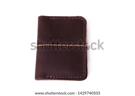 Handmade brown leather cardholder with rubber band isolated on white background closeup. Stock photo of handmade luxury accessories.