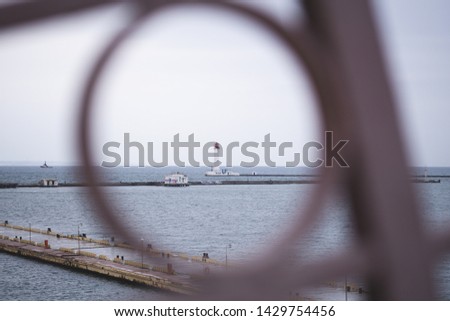 Lighthouse in the sea framed in matal ring 