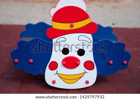 Small rocking carousel for children in the shape of a clown's face