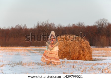 Russian girl in Pavlovo Posad shawl, scarf. Village bohemian lifestyle. Traditional national folk style in fashion. Pavlovoposadsky, Pavloposadsky shawl in countryside. Snow winter, nature of Russia