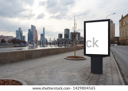 Billboard on an empty sidewalk in the city center. River bank, cloudy weather. Mock up.