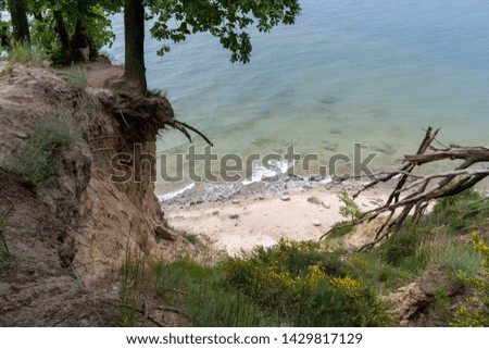Gdynia cliff at Poland, captured with full frame camera, capturing the drop and height of the cliff. Sunny day. Waves on the beach