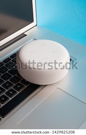Digital voice assistant and laptop with blue background