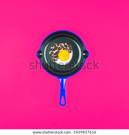Fried eggs on pink pans over pink background. Minimal Contemporary art collage . Leopard spot pattern texture. Flat lay, top view
