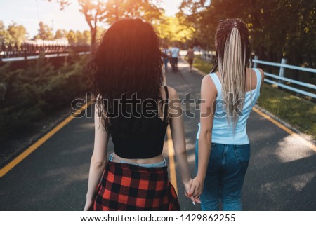 two female have friendship and walking in park holding by hands