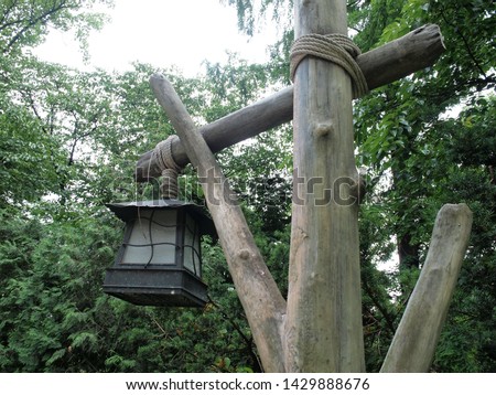 vintage oil lantern, hanging in wood pole in the forest