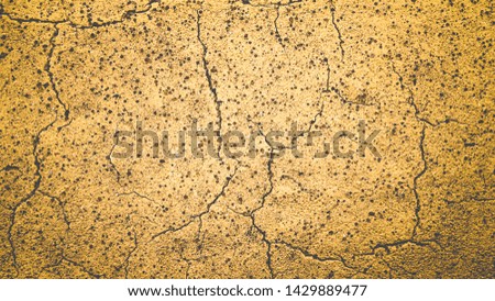 Crack lines and small dot holes on rough surface of old yellow painting cement concrete street for vintage background textured
