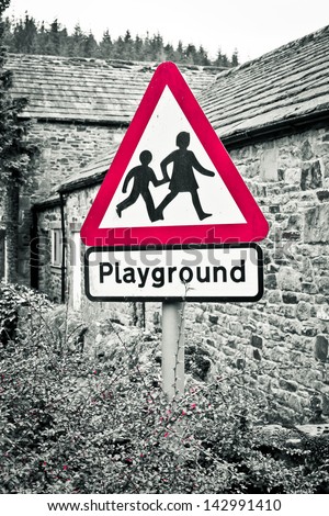 A playground warning sign with selective color desaturation
