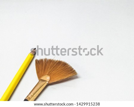 Yellow pencil and dusting converter on a white background