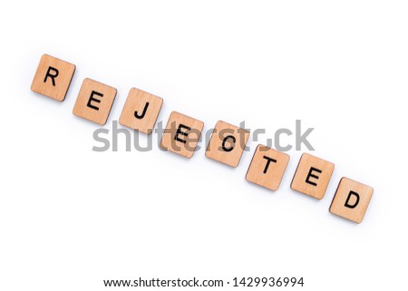 The word REJECTED, spelt with wooden letter tiles over a white background.