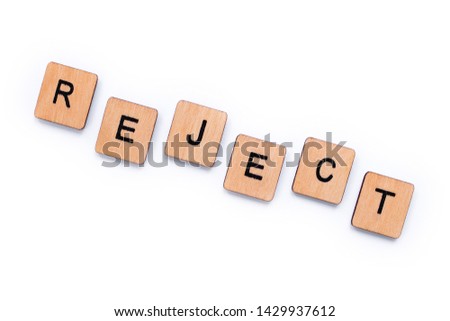 The word REJECT, spelt with wooden letter tiles over a white background.