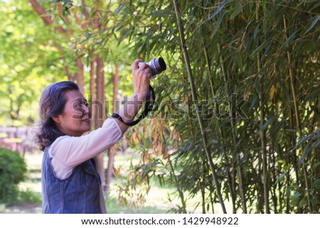 Asian adult woman taking pictures with plants