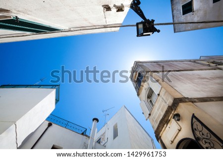 Old buildings and sky. Historic center of Otranto, Italy. Southern Italy. Wide view. Blue sky with the sun behind the building.
