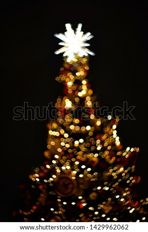 
multi-colored bokeh in the form of a Christmas tree on a black background