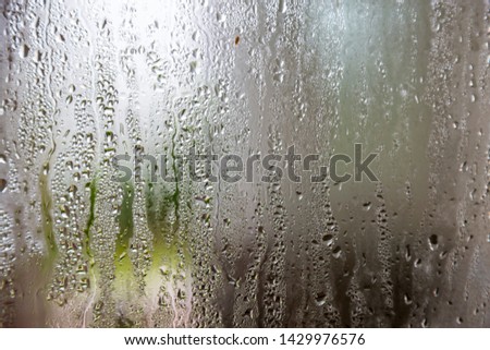 natural behind the wet glass with water drops on the glass background