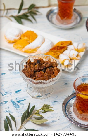 Tea set with varieties of traditional nuts, lemon, confiture and sweets served on white tablecloth - Image