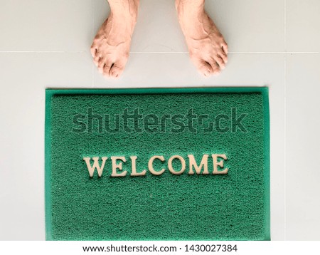 Welcome green mat in front of door, shop