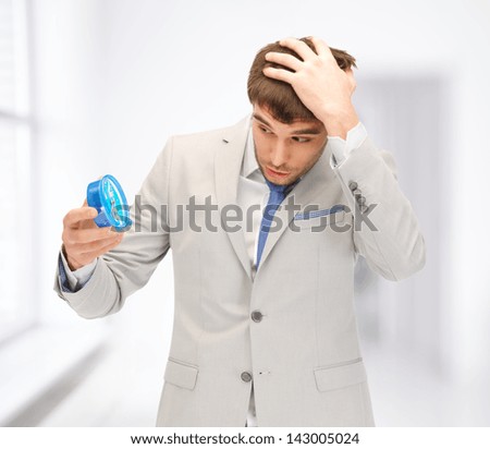 bright picture of handsome businessman looking at alarm clock