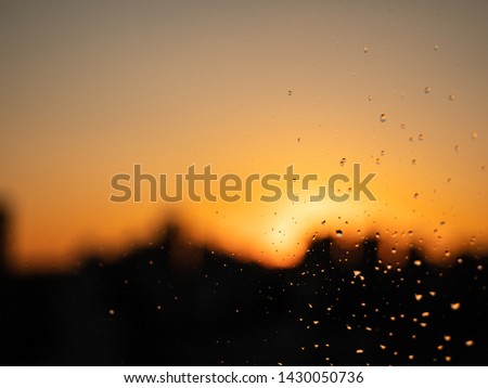 rain on the window and city in the background with sunset