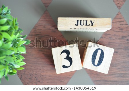 Date of July with leaf on diamond pattern table for background.