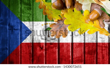 Equatorial Guinea flag on autumn wooden background with leaves and good place for your text.