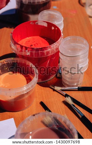 Liquid paint in plastic buckets. Manual work. Hand maid. Children's holiday.