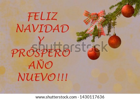 Fir tree branch with a red glitter ball and checked ribbon on soft light background.Bokeh effects. New year greetings card. "Feliz Navidad y Prospero año nuevo"