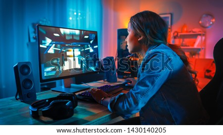 Pretty and Excited Black Gamer Girl Has a Tense Moment in Her First-Person Online Shooter Video Game on Her Computer. Room and PC have Colorful Neon Led Lights. Cozy Evening at Home.