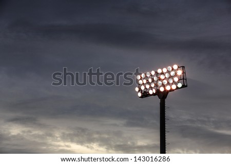 Stadium lights turn on at twilight time Royalty-Free Stock Photo #143016286