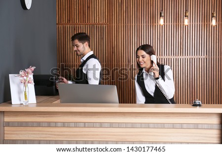 Receptionists working at desk in modern lobby Royalty-Free Stock Photo #1430177465