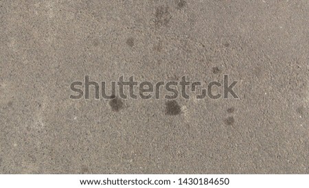drops of engine oil on asphalt in the daytime
