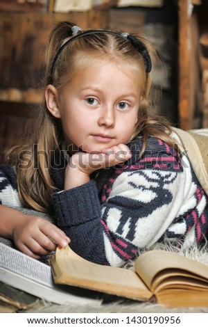 Girl schoolgirl reading book sheltering plaid