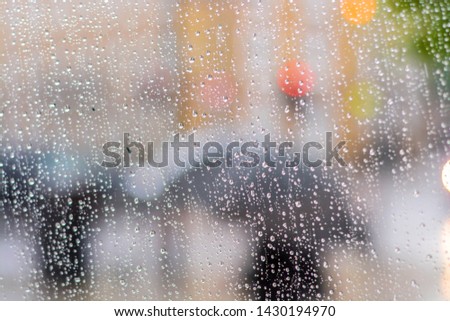 Rainy window. Out of focus people with umbrellas passing by Royalty-Free Stock Photo #1430194970
