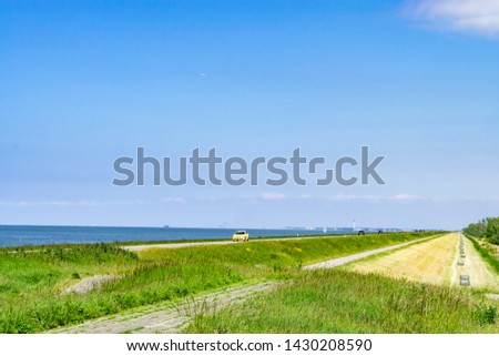 Summer landscape with car traveling along the sea. Hot summer landscape on the background of a large blue sky and the horizon line.