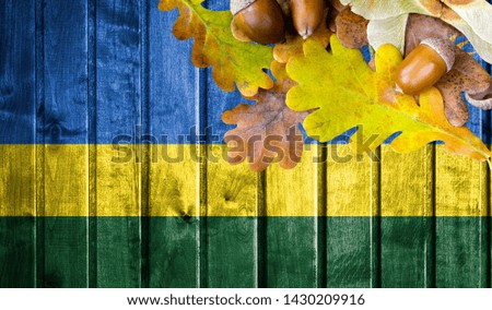 Rwanda flag on autumn wooden background with leaves and good place for your text.
