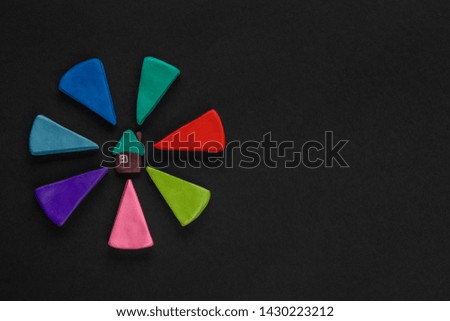 A house surrounded by colored arrows on black background, shot from above.