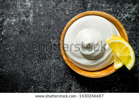 Mayonnaise with lemon slices. On dark rustic background