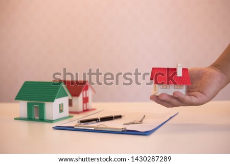 Mortgage concept. Man hand holding key with house.Banks approve loans to buy homes. 