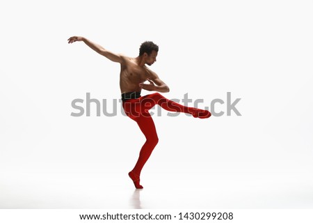 Graceful classic ballet dancer dancing isolated on white studio background. Man in bright red clothes like a combination of wine and milk. The dance, grace, artist, movement, action and motion concept