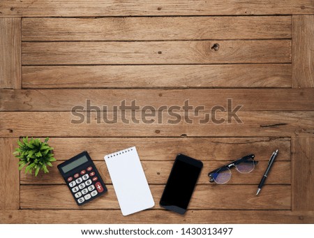 Office work table with tablet, Calculator, notepad, pots, glasses, pen and tablet on a wooden desk, Top view with copy space for text