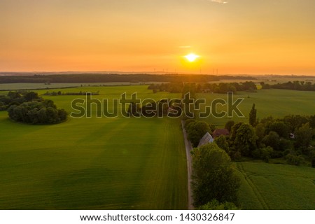 sunset over an agricultural field or meadow, sunset sky