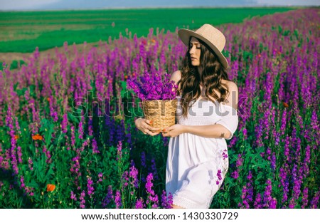 Thoughtful beauty young  woman surrounded by pink flowers - Stock image